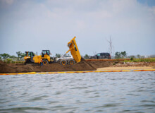 <a href="https://landscapearchitecturebuilt.com/west-pond-living-shoreline">West Pond Living Shoreline</a>, <br>Queens, NY, USA An image of landscape architecture project West Pond Living Shoreline, by design firm Dirtworks Landscape Architecture P.C, in Queens, NY, USA. Showing a dump truck dumping topsoil for planting